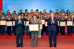 Chủ tịch nước Trần Đại Quang tặng hoa cho các Chủ tịch công đoàn cơ sở có thành tích đặc biệt xuất sắc. (Ảnh: Nhan Sáng/TTXVN) 