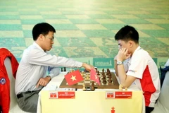 Kỳ thủ Lê Quang Liêm (trái) đấu ván thứ tư với Nguyễn Anh Khôi. (Ảnh: Hoàng Hải/Vietnam+)