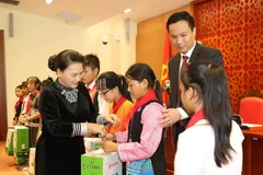 Chủ tịch Quốc hội Nguyễn Thị Kim Ngân tặng quà cho các cháu thiếu nhi. (Ảnh: Trọng Đức/TTXVN)