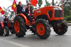 Cổ động viên lái máy cày diễu phố tại đường Hoàng Quốc Việt (Cầu Giấy). (Ảnh: Nguyễn Thắng/TTXVN)