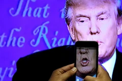 Một nhà báo ghi lại hình ảnh ông Donald Trump trong cuộc tranh luận với bà Hillary. (Nguồn: Reuters)