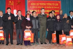 Bộ trưởng Bộ Công an Tô Lâm và lãnh đạo tỉnh Sơn La tặng quà các gia đình có công với cách mạng tại xã Lóng Luông, huyện Vân Hồ, tỉnh Sơn La. (Ảnh: Nguyễn Cường/TTXVN)