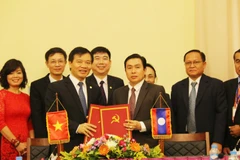 Phó Chánh Văn phòng Trung ương Đảng Cộng sản Việt Nam Bùi Văn Thạch (trái) và Phó Chánh Văn phòng Trung ương Đảng Nhân dân cách mạng Lào Khampha Phimmasone ký Biên bản bàn giao. (Ảnh: Xuân Tú/TTVXN)