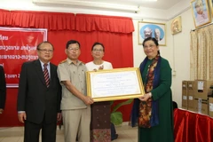 Phó Chủ tịch Thường trực Quốc hội Tòng Thị Phóng trao tặng quà cho Trường PTTH Hữu nghị Việt Nam-Lào. (Ảnh: Xuân Tú/TTXVN)