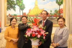 Đại sứ Lê Quý Quỳnh (trái) tặng hoa chúc Đại sứ Houmdaophone Soukhaseum nhân dịp quốc khánh lần thứ 43 của Lào. (Ảnh: Lê Hòa/Vietnam+)