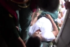 Đưa bệnh nhân lên máy bay cấp cứu. (Nguồn: Vnews)