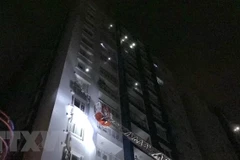 Lực lượng phòng cháy chữa cháy thực hiện công tác cứu hộ, đưa người dân ra khỏi hiện trường vụ cháy. (Ảnh: Linh Sơn/TTXVN)
