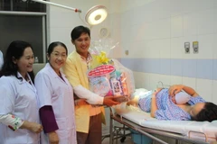 Phó Bí thư Thành ủy Thành phố Hồ Chí Minh Võ Thị Dung tặng quà cho gia đình những công dân tuổi Đinh Dậu ra đời đầu tiên. (Ảnh: Xuân Dự/TTXVN)