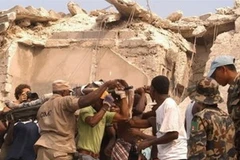 Người dân Haiti đưa nạn nhân ra khỏi đống đổ nát sau vụ động đất. (Ảnh: AP)