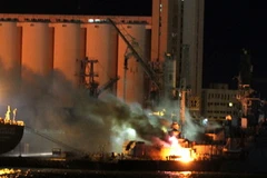 Một con thuyền bốc cháy sau trận oanh tạc của NATO tại cảng Tripoli ngày 19/5. (Nguồn: AFP/ TTXVN)