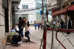 Di dời vật dụng ra khỏi ngôi nhà. (Ảnh: Tuấn Anh/TTXVN)