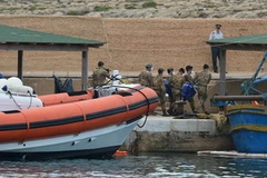 Đưa thi thể nạn nhân của vụ lật tầu vừa được tìm thấy lên bờ. (Nguồn: AFP/TTXVN)