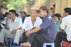 Những ánh mắt đắm đuối đợi con của phụ huynh ngoài phòng thi. (Ảnh: Thông Chí/Vietnam+)
