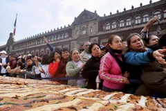 Người dân tập trung đợi được phân phát bánh truyền thống "Rosca de Reyes". (AFP- TTXVN)