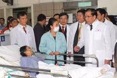 Tổng Bí thư Nông Đức Mạnh thăm bệnh nhân đang điều trị tại bệnh viện. (Ảnh: Đinh Xuân Tuân/TTXVN) 