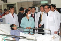 Tổng Bí thư Nông Đức Mạnh thăm bệnh nhân đang điều trị tại bệnh viện. (Ảnh: Đinh Xuân Tuân/TTXVN) 