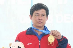 Xạ thủ Mạnh Tường với tấm huy chương vàng muộn mằn. (Ảnh: Hoàng Hà/TTXVN)