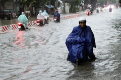 Các phương tiện tham gia lưu thông gặp nhiều khó khăn trên tuyến đường đường 21 tháng 8, phường Phước Mỹ (thành phố Phan Rang-Tháp Chàm) do bị ngập sâu. (Ảnh: Công Thử/TTXVN)