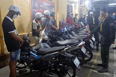 Các đối tượng đua xe bị tạm giữ. (Ảnh: TTXVN phát)