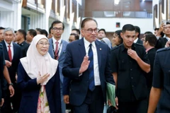 Thủ tướng Malaysia (giữa) rời phiên họp Hạ viện sau cuộc đánh giá tín nhiệm, ở Kuala Lumpur. (Ảnh: AFP/TTXVN)