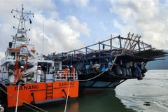 Tàu SAR 412 lai dắt tàu cá bị nạn cập bờ an toàn. (Ảnh: TTXVN phát)