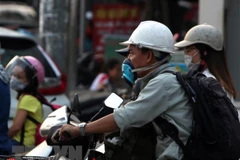 Người dân đeo khẩu trang khi ra ngoài đường. (Ảnh: Danh Lam/TTXVN)