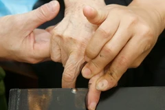 Lấy dấu vân tay làm thủ tục cấp đổi chứng minh thư nhân dân đã hết hạn sử dụng cho một người dân gặp khó khăn trong việc đi lại. (Ảnh minh họa: Thống Nhất/TTXVN).