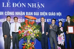 Phó Chủ tịch Ủy ban Trung ương Mặt trận Tổ quốc Việt Nam Lê Bá Trình (áo trắng, bên trái) tặng hoa chúc mừng Ban đại diện Giáo hội tại buổi lễ. (Ảnh: Nguyễn Dân/TTXVN)