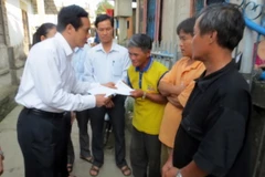 Phó Chủ tịch Ủy ban Trung ương Mặt trận Tổ quốc Việt Nam Lê Bá Trình thăm và tặng quà cho ngư dân. (Ảnh: Quốc Việt/TTXVN)