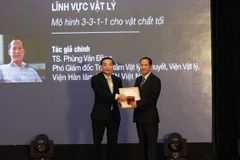 Bộ trưởng Bộ Khoa học và Công nghệ Chu Ngọc Anh (bên trái) trao giải thưởng "Nhà khoa học trẻ có công trình khoa học xuất sắc" cho tiến sỹ Phùng Văn Đồng, Viện Vật Lý, Viện Hàn lâm Khoa học và Công nghệ Việt Nam. (Ảnh: Anh Tuấn/TTXVN)