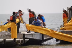 Công nhân đặt rào chắn ngăn dầu loang ở Vịnh Mexico. (Nguồn: AFP/TTXVN)