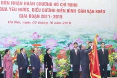 Thường trực Ban Bí thư Lê Hồng Anh gắn Huân chương Hồ Chí Minh lên Cờ truyền thống của Ban Dân vận Trung ương. (Ảnh: Phương Hoa/TTXVN)