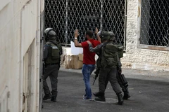 Nhân viên an ninh Israel bắt giữ một người Palestine sau cuộc đụng độ tại làng al-Ram, nằm giữa Jerusalem và Ramallah, Bờ Tây. (Nguồn: AFP/TTXVN)