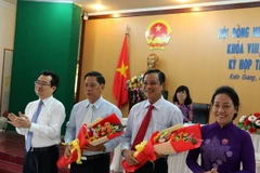 Ông Phạm Vũ Hồng (thứ 2 từ phải sang) nhận hoa chúc mừng. (Ảnh: Lê Huy Hải/TTXVN)