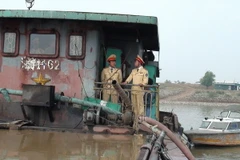 Lực lượng Cảnh sát giao thông đường thủy-Công an tỉnh Bắc Ninh bắt giữ tàu BKS HD-0612 khai thác cát sỏi trái phép trên sông Đuống. (Ảnh: Thái Hùng/TTXVN)