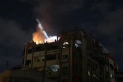Một tòa nhà bốc cháy sau cuộc không kích của Israel tại Dải Gaza ngày 9/5. (Ảnh: AA/TTXVN)