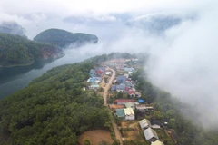 Xóm tái định cư Lau Bai, một bản người Dao đẹp thơ mộng, với vị trí địa lý đắc địa tọa lạc trên ngọn đồi hình yên ngựa, xuôi dần về phía hồ, cùng cảnh quan núi, sông kỳ vỹ. (Ảnh: Trọng Đạt/TTXVN)