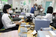 Khách hàng giao dịch tại Vietcombank chi nhánh Vĩnh Phúc. (Ảnh: Trần Việt/TTXVN)