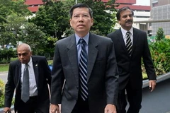 Ông Peter Lim (giữa) trên đường đến tòa (Nguồn: AFP)