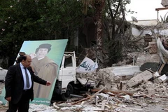 Thứ trưởng Ngoại giao Libya Khaled Kaim chỉ cho các nhà báo quốc tế hiện trường của tòa nhà quốc hội Libya bị trúng bom NATO (Nguồn: CNN)