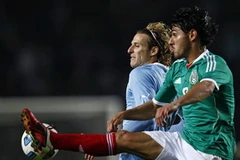 Pha tranh bóng của Forlan với một cầu thủ Mexico (Nguồn: Reuters)