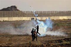 Người biểu tình Palestine ném trả đạn hơi cay về phía binh sĩ Israel trong cuộc đụng độ tại khu vực biên giới Dải Gaza-Israel, ngày 1/9/2023. (Ảnh: THX/TTXVN)