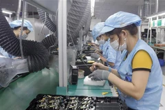 Công nhân Công ty TNHH Telstar Việt Nam, Khu Công nghiệp Vân Trung, Bắc Giang (vốn đầu tư của Anh) trong dây truyền sản xuất thiết bị điện tử. (Ảnh: Đồng Thúy/TTXVN)