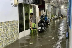 Nhiều hộ dân tại một tuyến hẻm trên đường Phan Huy Ích (quận Tân Bình) phải rào chắn, chốt chặt cửa để ngăn nước tràn vào nhà. (Ảnh: Hồng Giang/TTXVN)