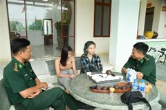 Lực lượng Bộ đội Biên phòng tỉnh Tây Ninh nghe hai nữ nạn nhân kể lại sự việc sau khi được giải cứu. (Ảnh: TTXVN phát)