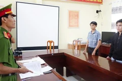 Cơ quan Cảnh sát Điều tra Công an thành phố Long Xuyên (tỉnh An Giang) thi hành lệnh khởi tố vụ án, khởi tố bị can và bắt tạm giam đối với Lê Đăng Khoa và Phan Văn Đức. (Ảnh: TTXVN phát)