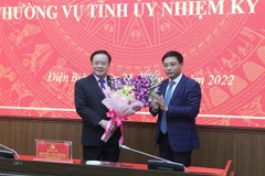 Ông Nguyễn Văn Thắng, Ủy viên Ban Chấp hành Trung ương Đảng, Bộ trưởng Bộ Giao thông Vận tải tặng hoa chúc mừng ông Mùa A Sơn, Phó Bí thư thường trực Tỉnh ủy Điện Biên. (Ảnh: Xuân Tiến/TTXVN)