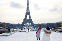Khách du lịch chụp ảnh lưu niệm dưới chân tháp Eiffel. (Nguồn: news.yahoo.com)