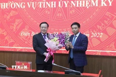 Ông Nguyễn Văn Thắng, Ủy viên Ban Chấp hành Trung ương Đảng, Bộ trưởng Bộ Giao thông Vận tải tặng hoa chúc mừng ông Mùa A Sơn, Phó Bí thư thường trực Tỉnh ủy Điện Biên. (Ảnh: Xuân Tiến/TTXVN)