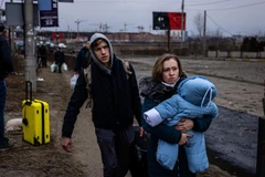 Người dân Ukraine sơ tán khỏi thành phố Irpin, phía Tây Bắc thủ đô Kiev. (Ảnh: AFP/TTXVN)